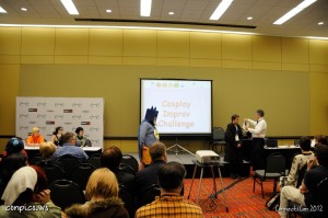 Genre Wars Panel. The MC telling contestants their characters.